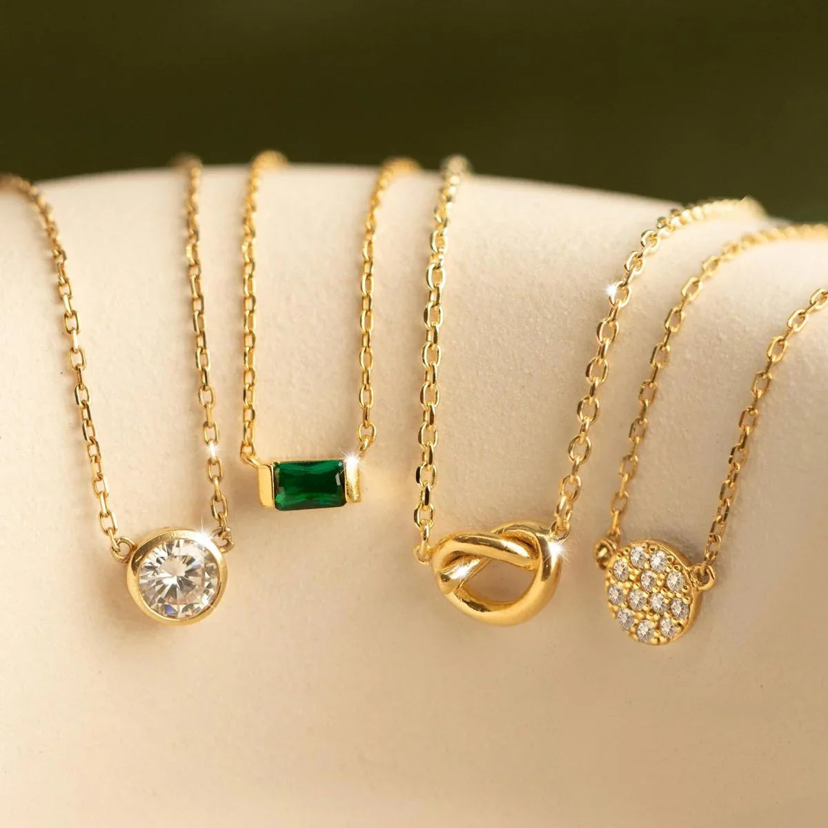 Elegant collection of fine jewelry necklaces featuring gold chains and sparkling pendants