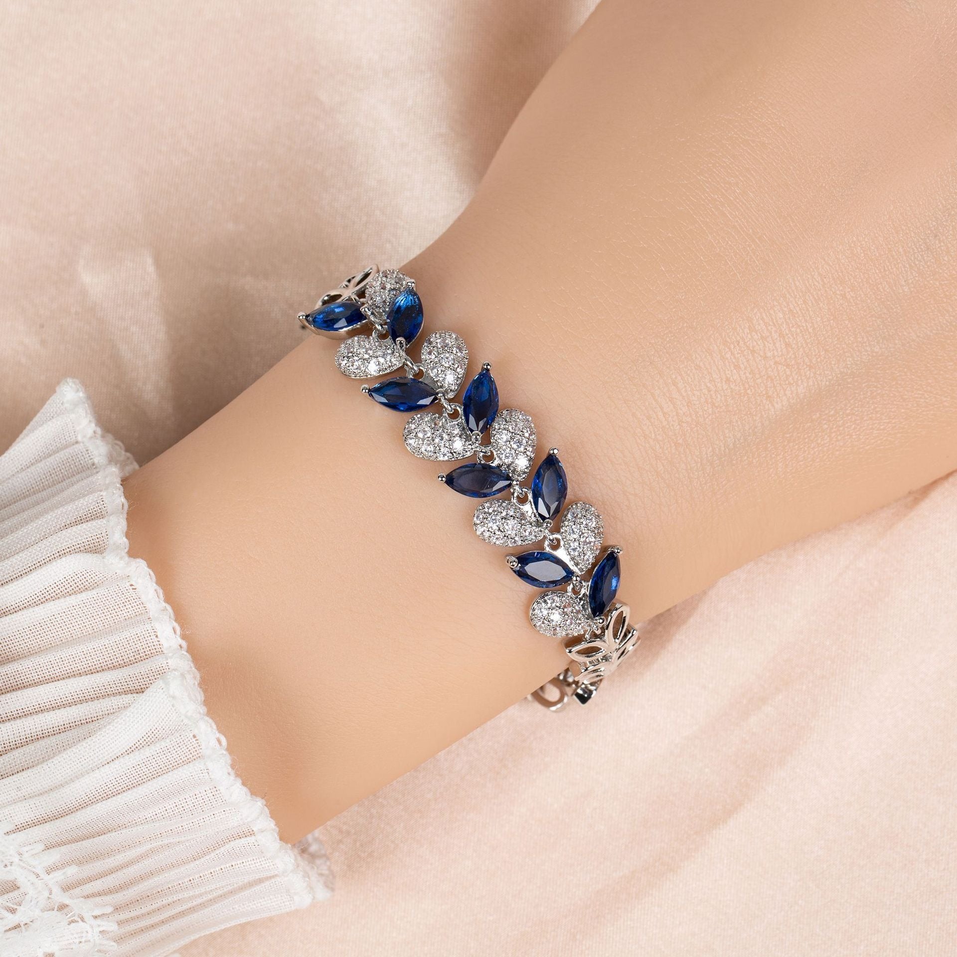 S925 Sterling Silver Micro-Pavé Zirconia Leaf and Fishtail Link Chain Bracelet White background with royal blue